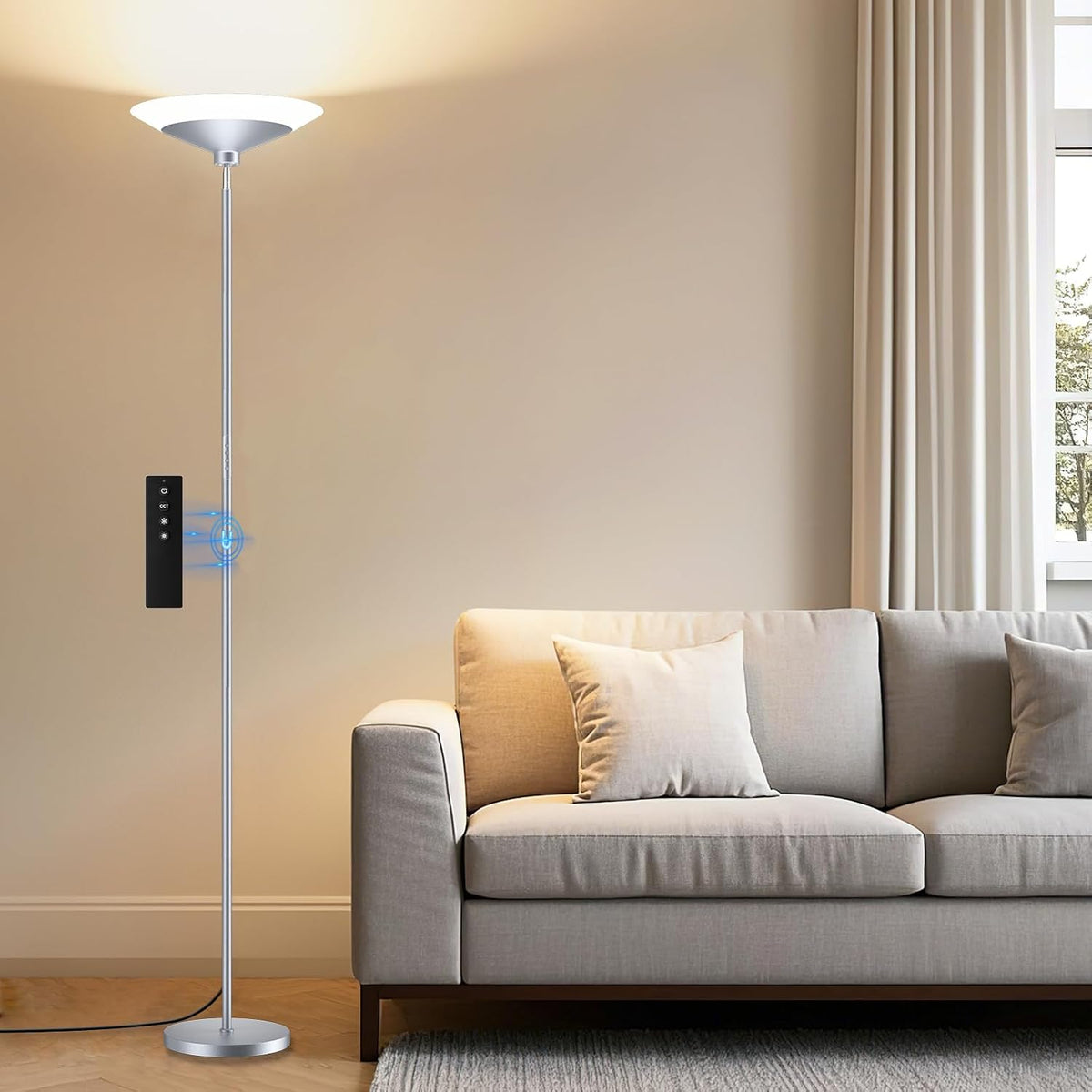SIBRILLE 72-inch LED torchiere: silver torchiere with remote beside a sofa.