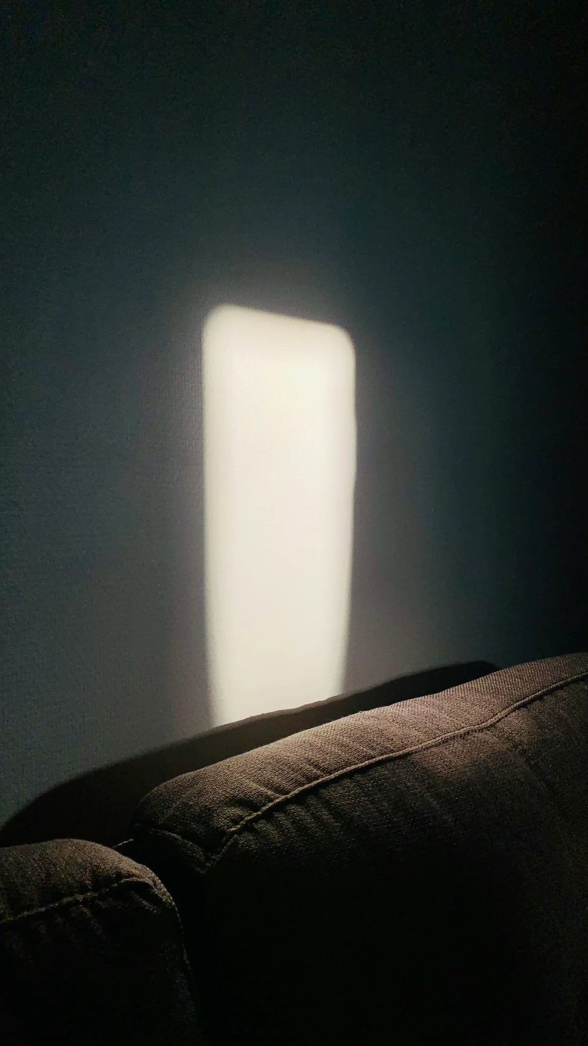 Soft lamp light on a wall behind a sofa
