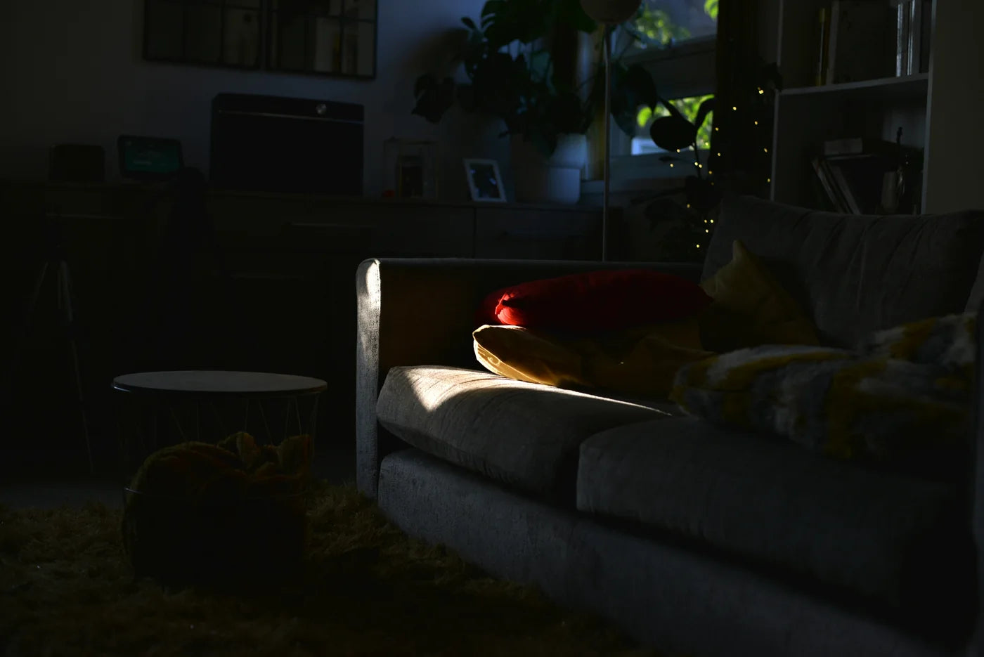 A dim living room with a soft light on the sofa
